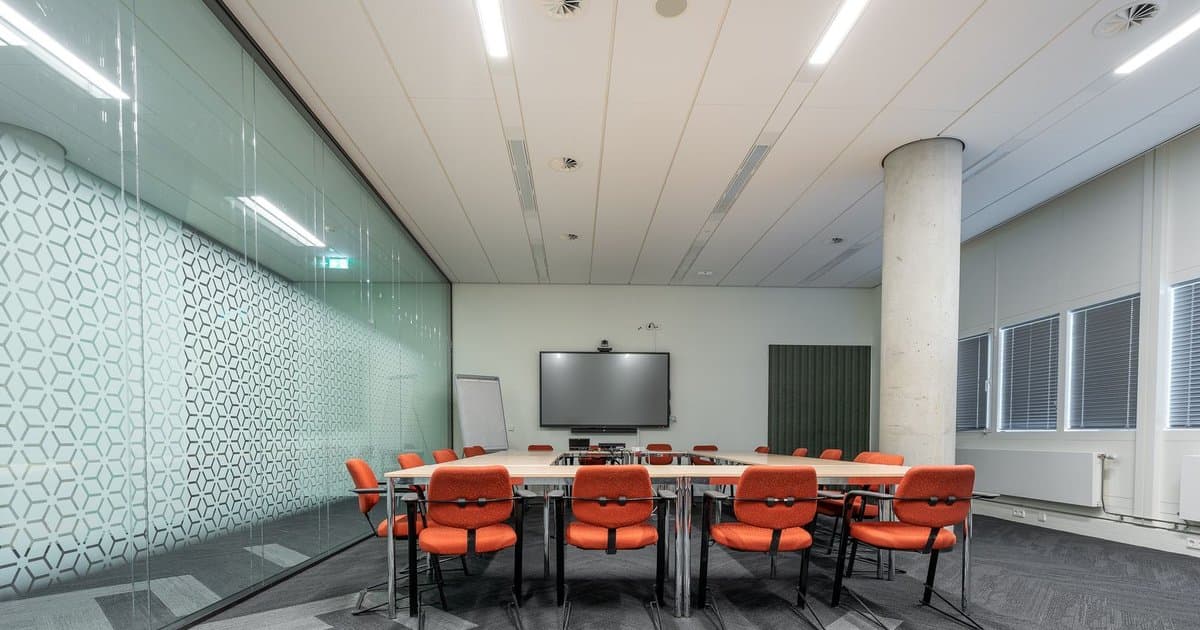 Meeting room with a wall display and video conferencing camera mounted above the screen