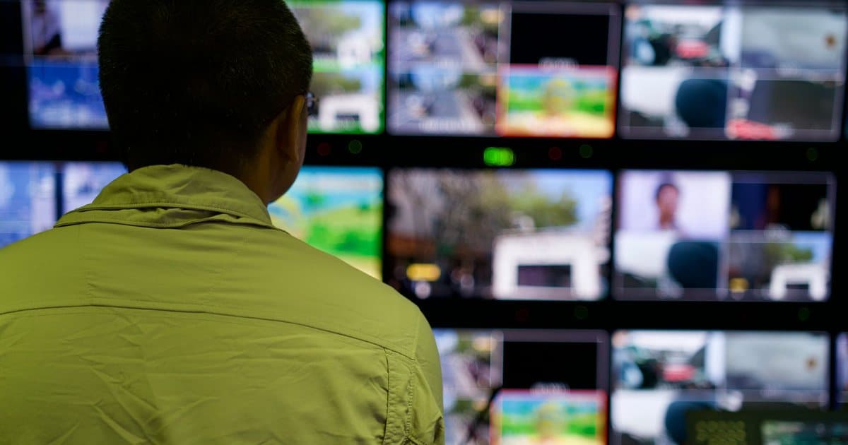 Operator watching a wall of surveillance monitors in a UAE security control room